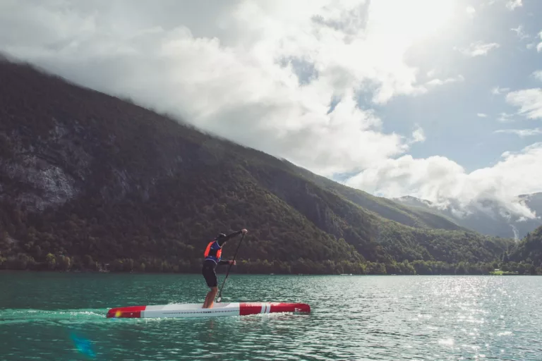 Un rameur seul sur l'eau plate du lac d'Aiguebelette pendant la Very Flat Race